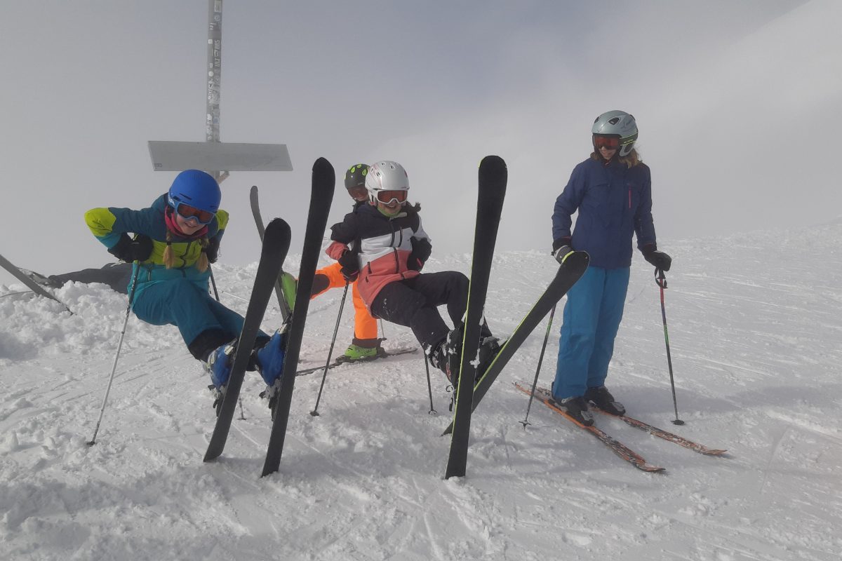 Drei Skifahrer posieren mit Ski im Nebel