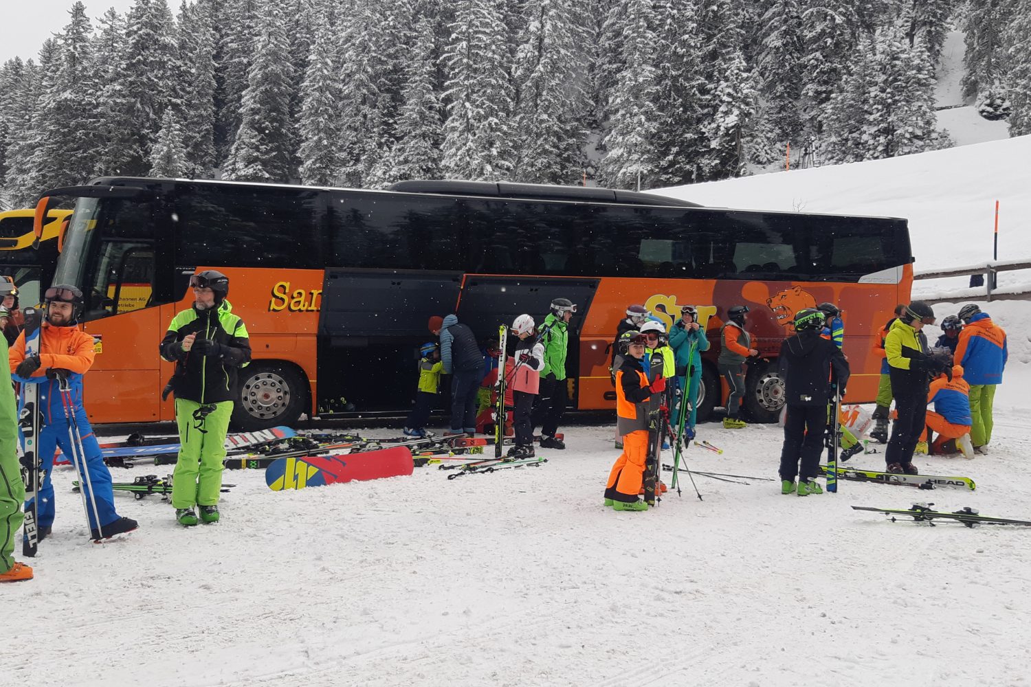 Skiclub-Gruppe vor dem Car im Schnee